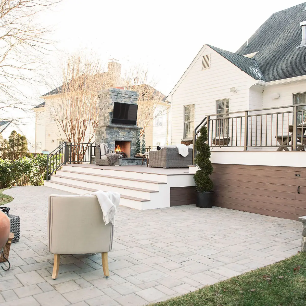 beautiful landscaped backyard with a deck, patio and fireplace