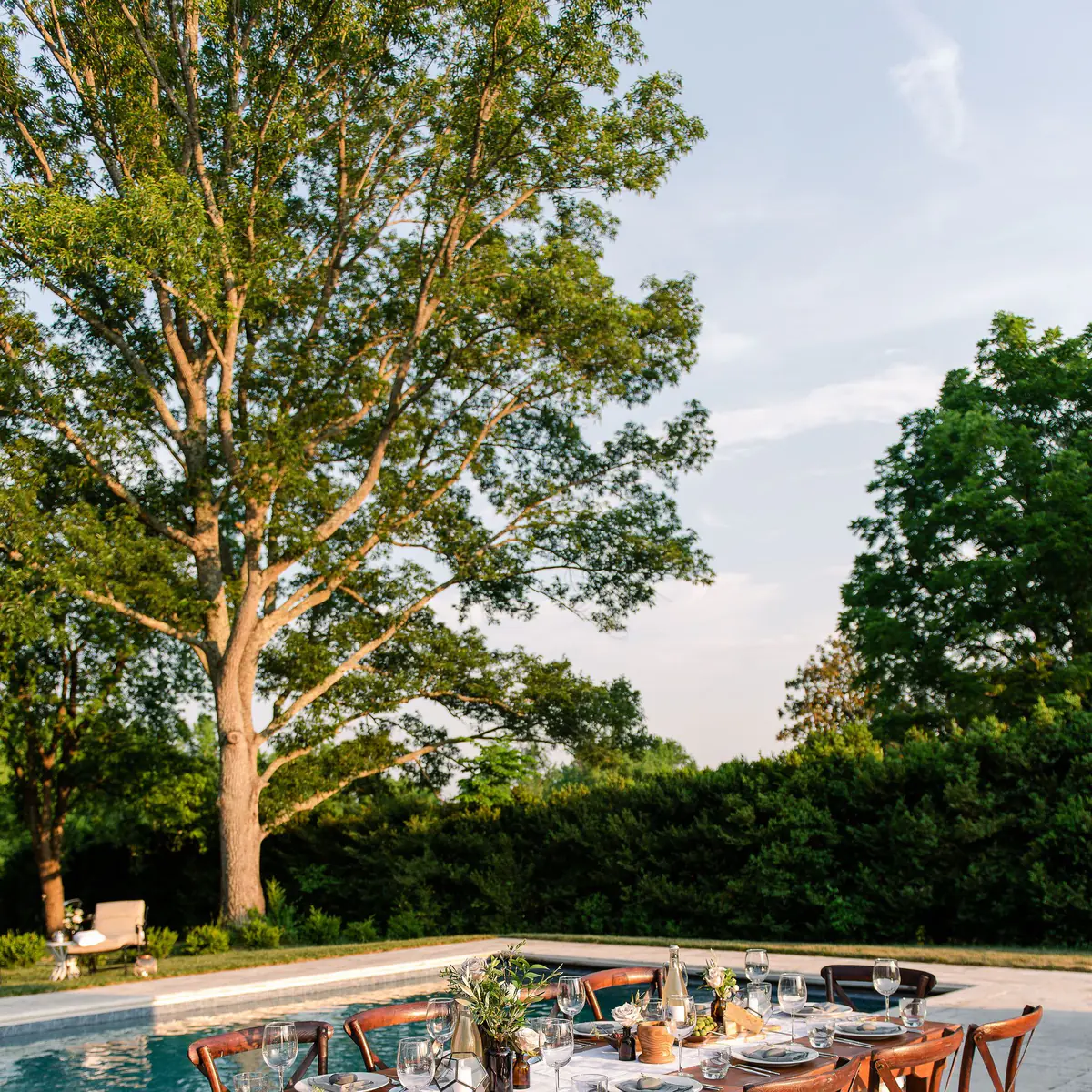 Elegant patio dining next to pool with travertine pool decking