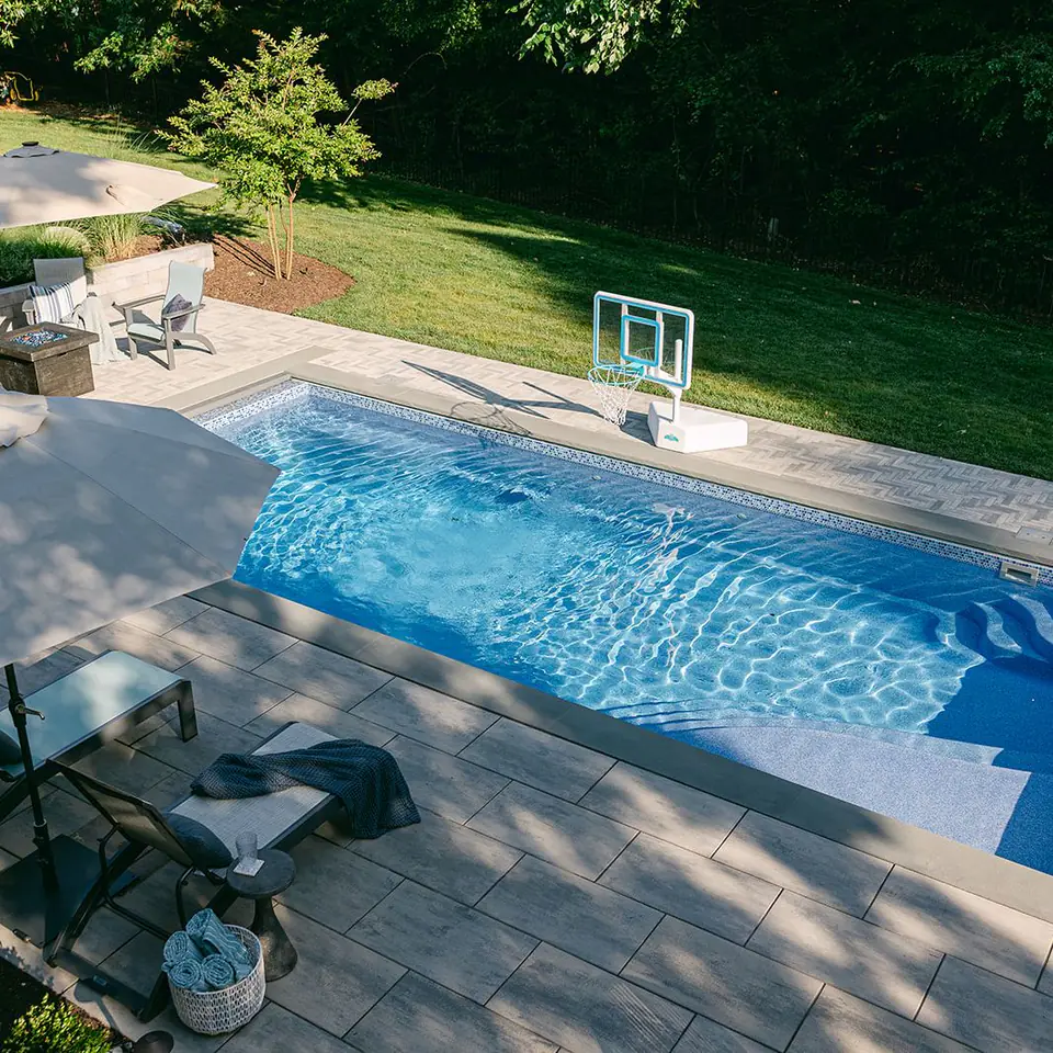 fiberglass swimming pool with paver pool decking
