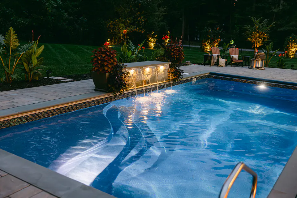 pool with water feature and lighting