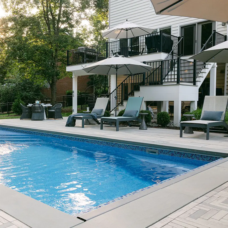 fiberglass swimming pool with concrete pavers and composite deck