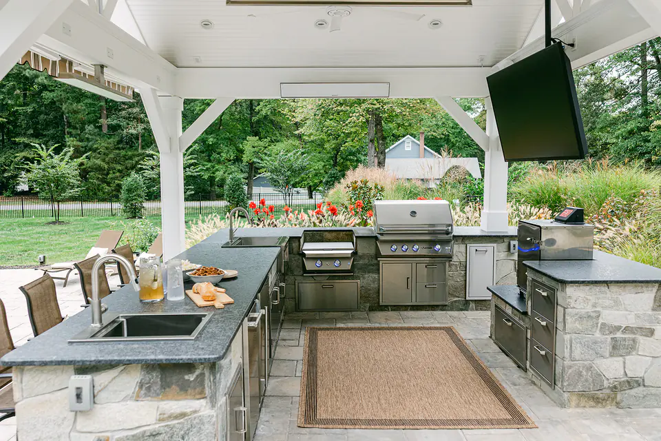 outdoor kitchen under pavilion with outdoor tv